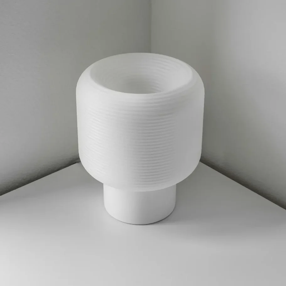 Weiße, moderne Lampe mit schichtenförmigem Design in einer Ecke.